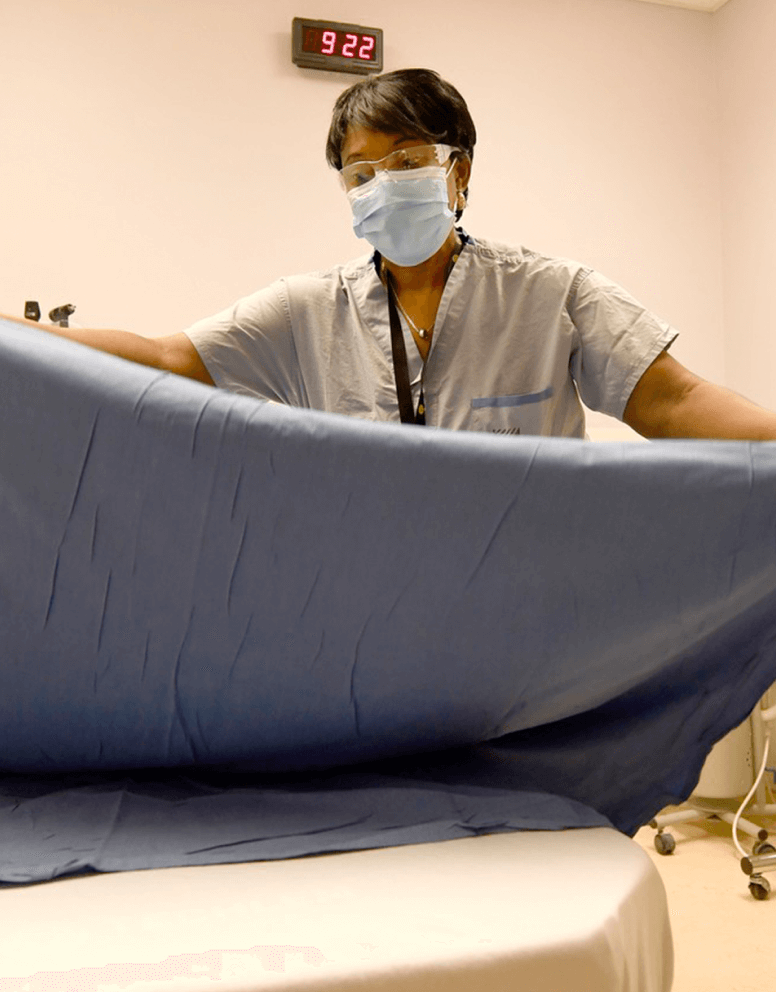 Health care worker changing bedding at William Osler Health System.