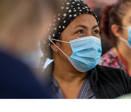 A healthcare worker wearing a headscarf and mask.  